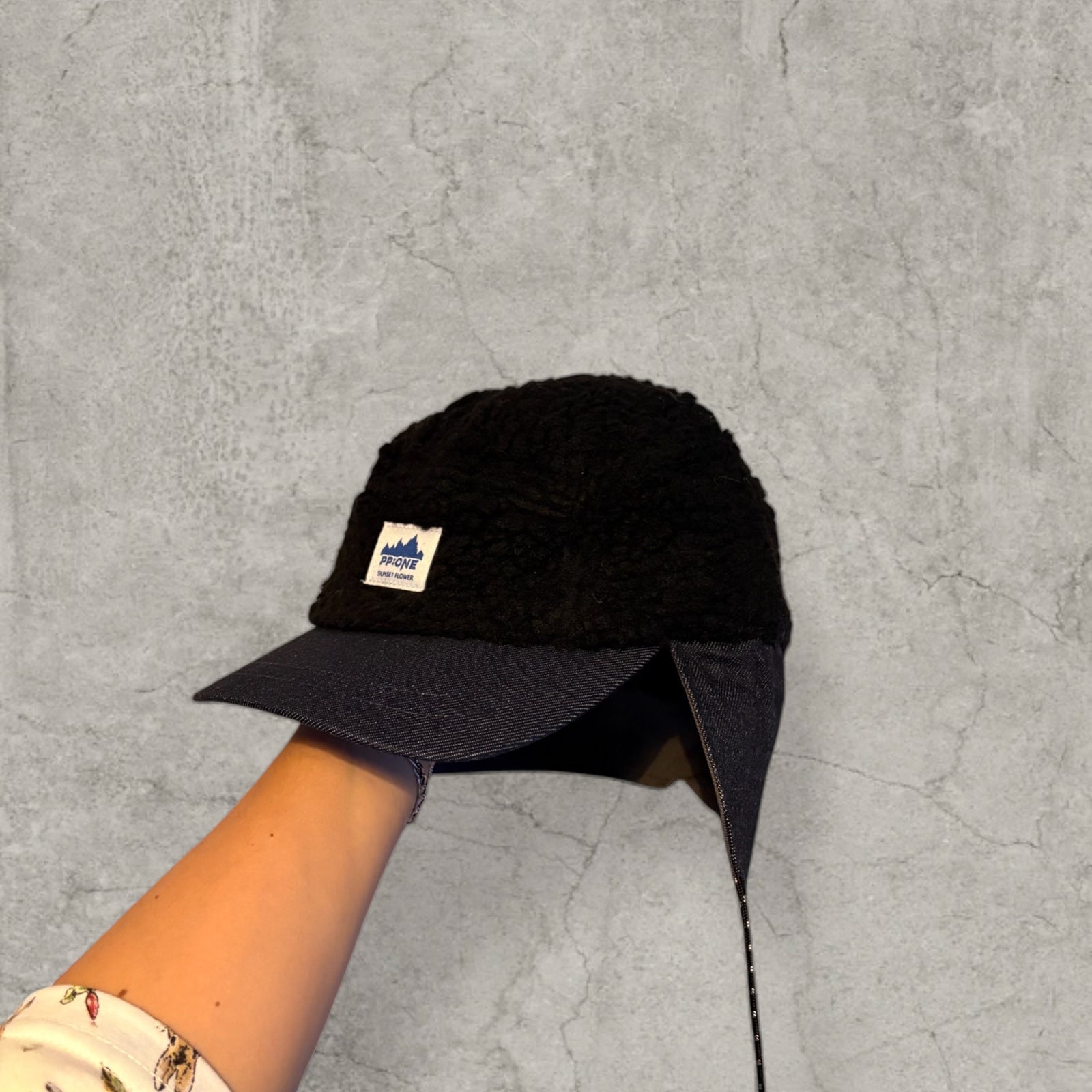 Trapper Russian cap black fleece and navy ear flaps.