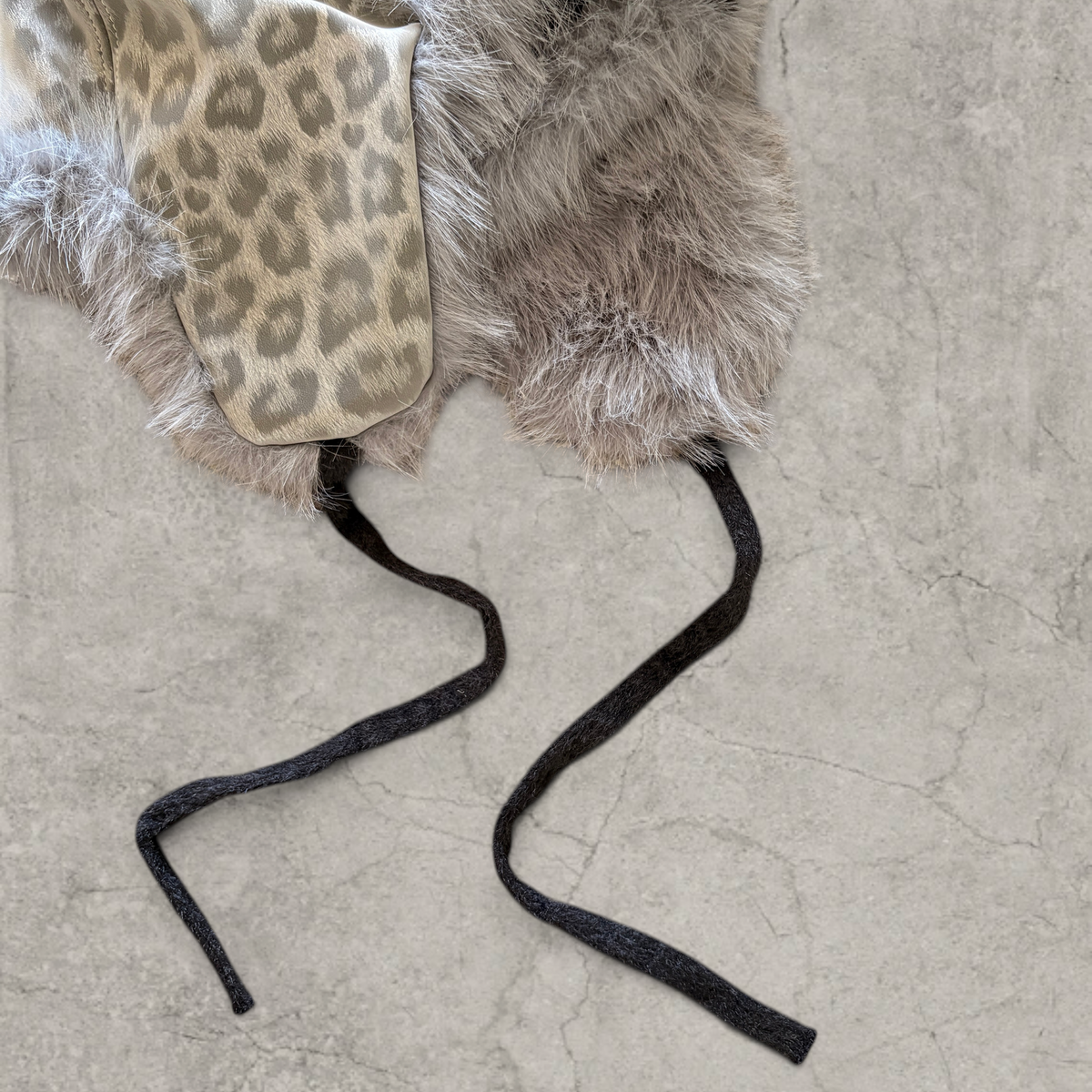 Russian trapper bonnet hat in grey silver animal leopard print with grey fur.