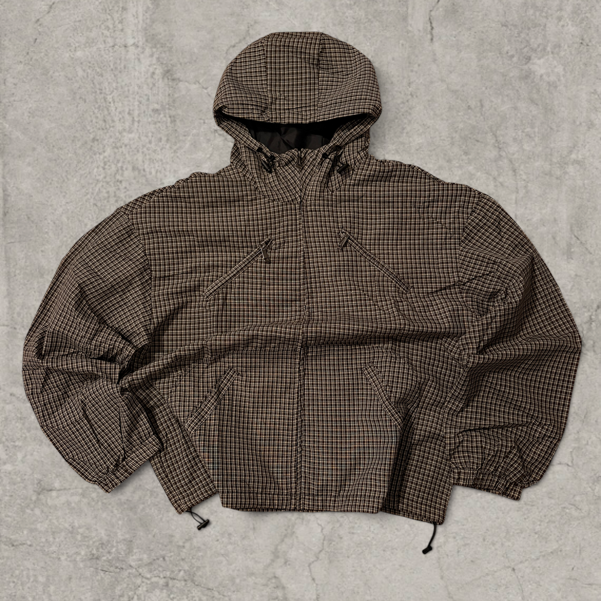 Black and brown checkered gorpcore jacket hood and zip.