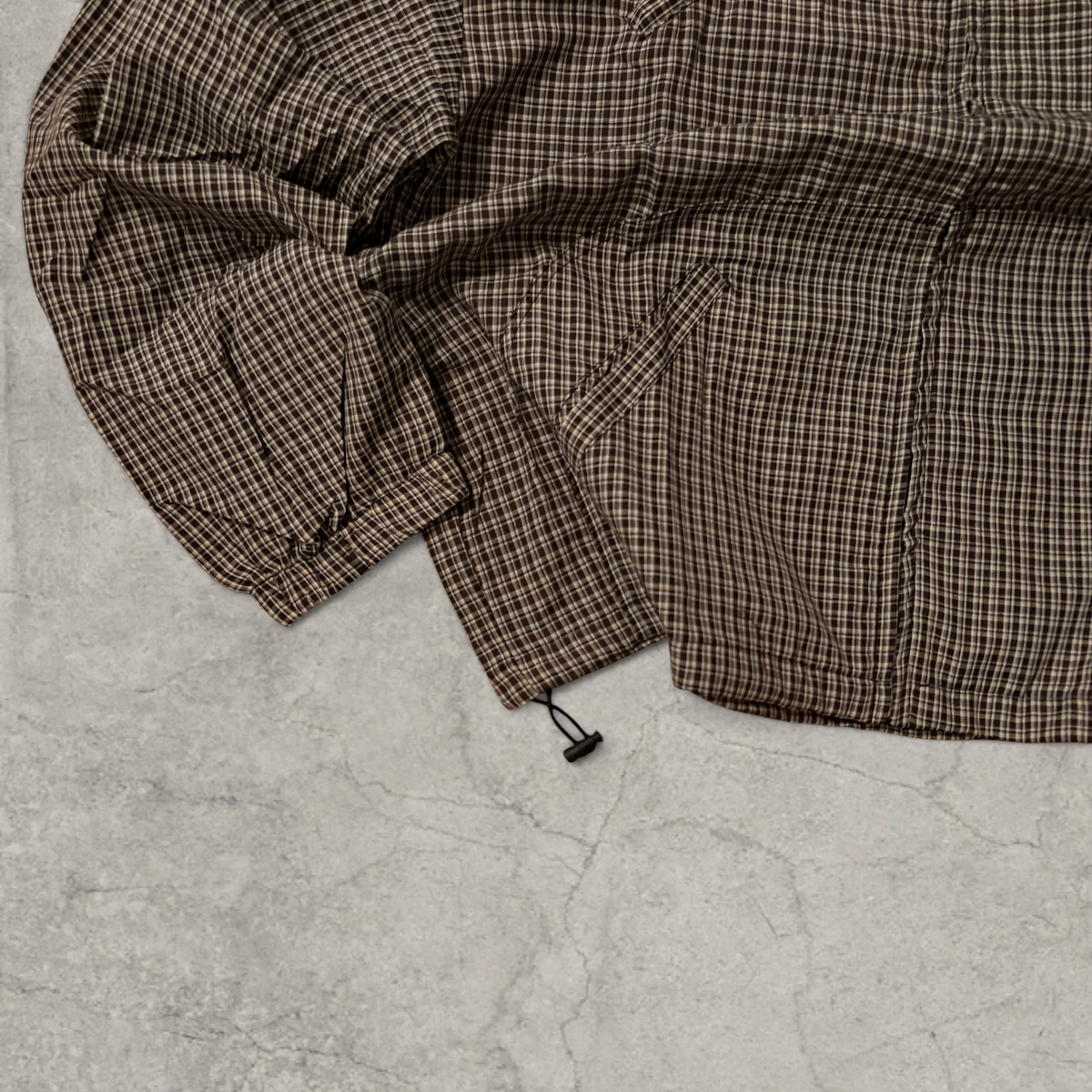 Black and brown checkered gorpcore jacket hood and zip.