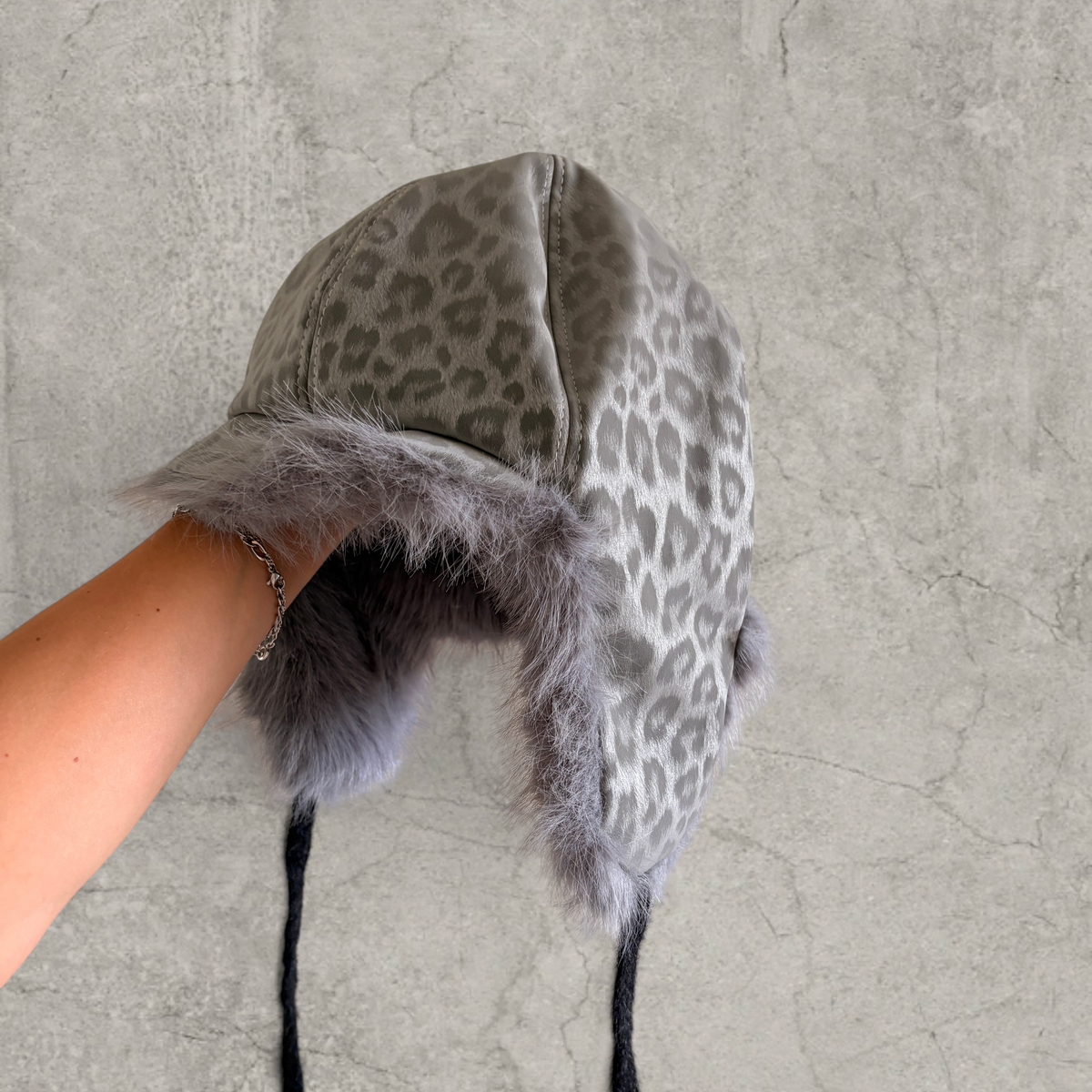 Russian trapper bonnet hat in grey silver animal leopard print with grey fur.