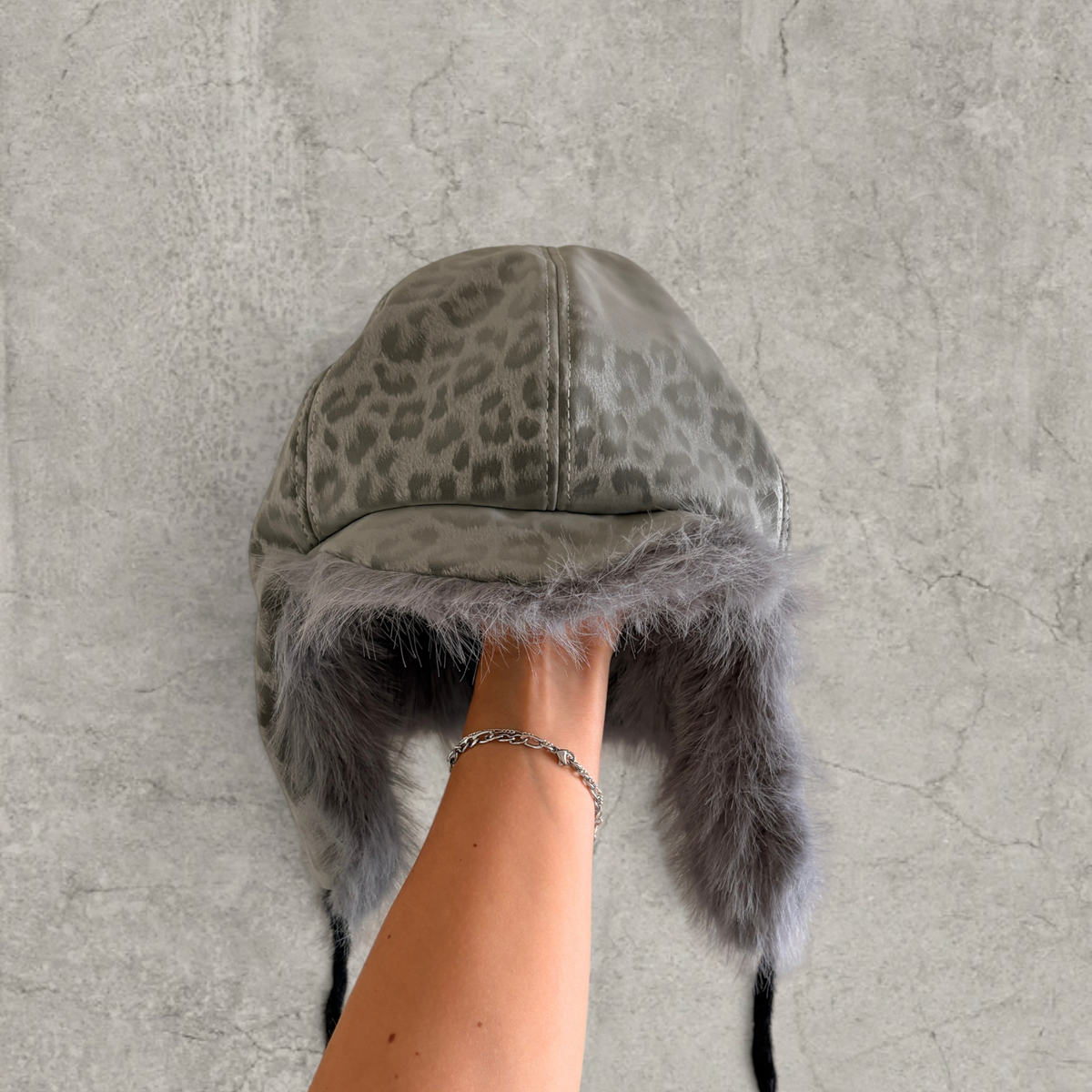 Russian trapper bonnet hat in grey silver animal leopard print with grey fur.