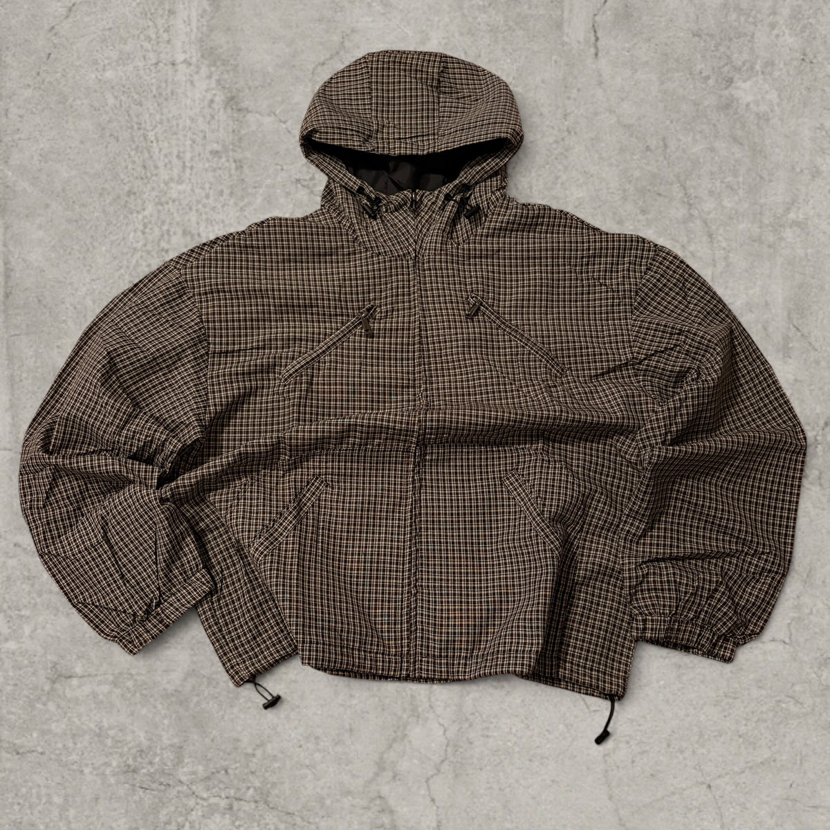 Black and brown checkered gorpcore jacket hood and zip.