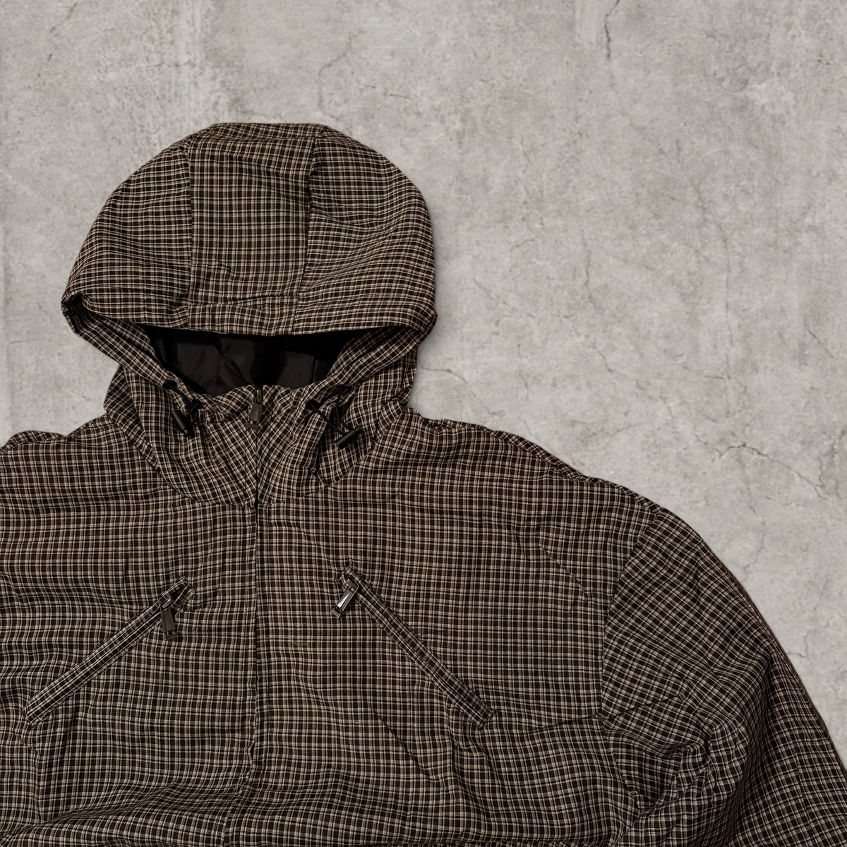 Black and brown checkered gorpcore jacket hood and zip.