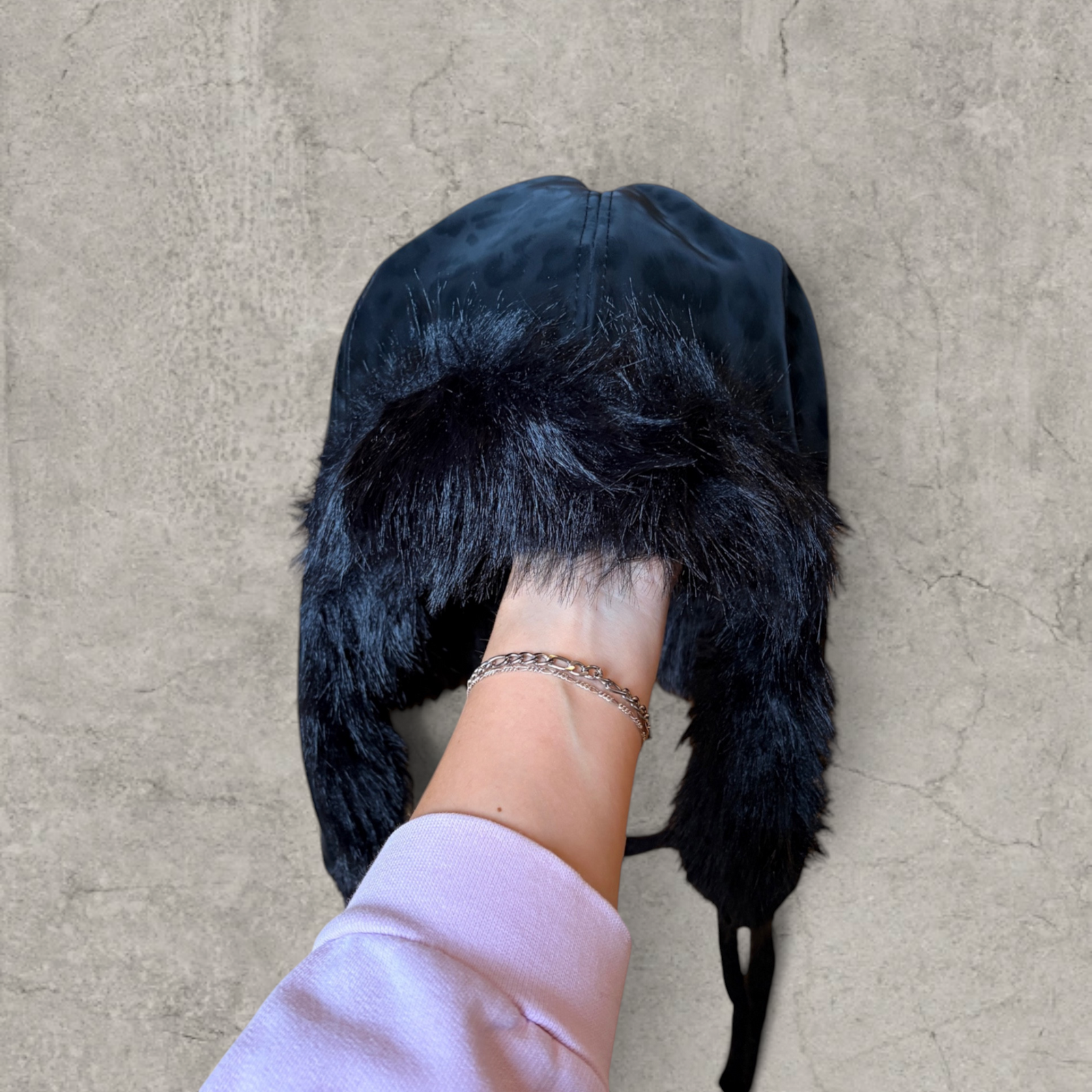 Russian trapper bonnet hat in black animal leopard print with black fur.