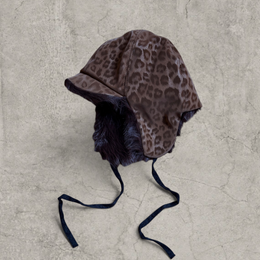 Russian trapper bonnet hat in beige animal leopard print with brown fur.