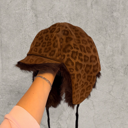 Russian trapper bonnet hat in beige animal leopard print with brown fur.