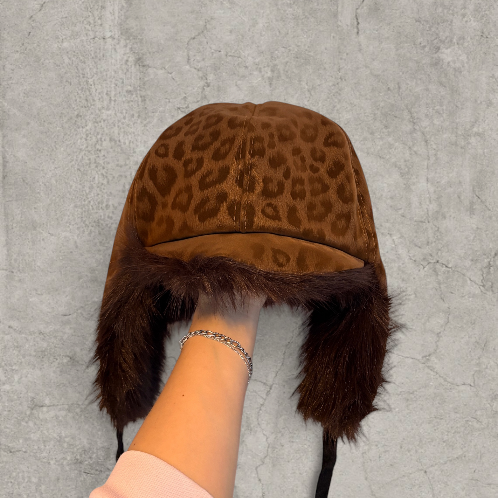 Russian trapper bonnet hat in beige animal leopard print with brown fur.