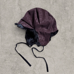 Russian trapper bonnet hat in dark brown animal leopard print with black fur.