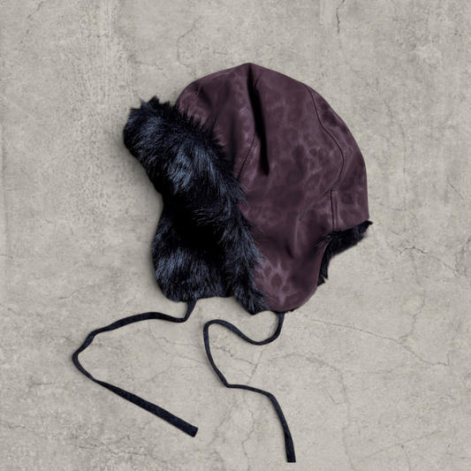 Russian trapper bonnet hat in dark brown animal leopard print with black fur.