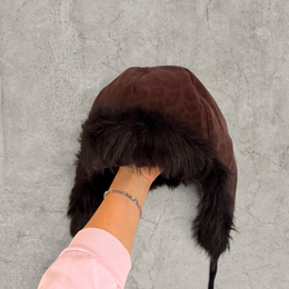 Russian trapper bonnet hat in dark brown animal leopard print with black fur.
