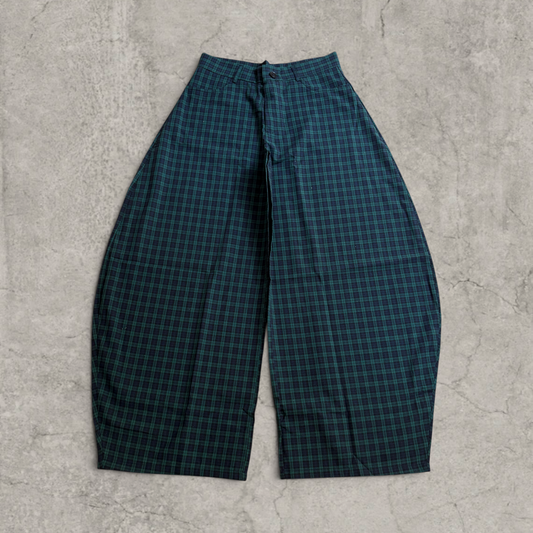 Navy blue and dark green checkered wide-leg trousers laid flat on a grey surface front view