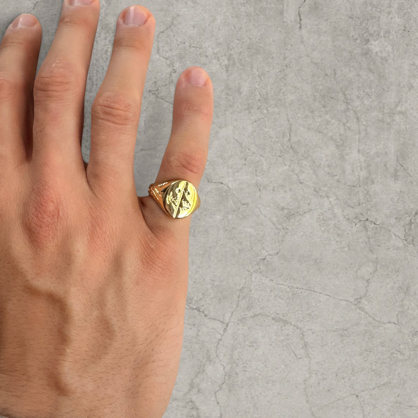 Colour stainless steel signet ring in gold with sword engraved emblem.
