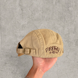 Flat peak beret cap in brown/beige with Boston logo.