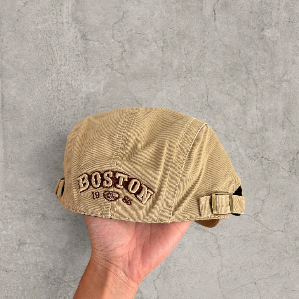 Flat peak beret cap in brown/beige with Boston logo.