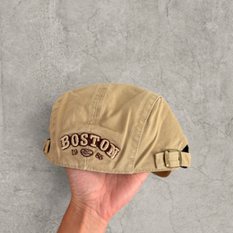 Flat peak beret cap in brown/beige with Boston logo.