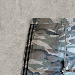 Wide-leg skater jeans with camouflage print and black stripes.