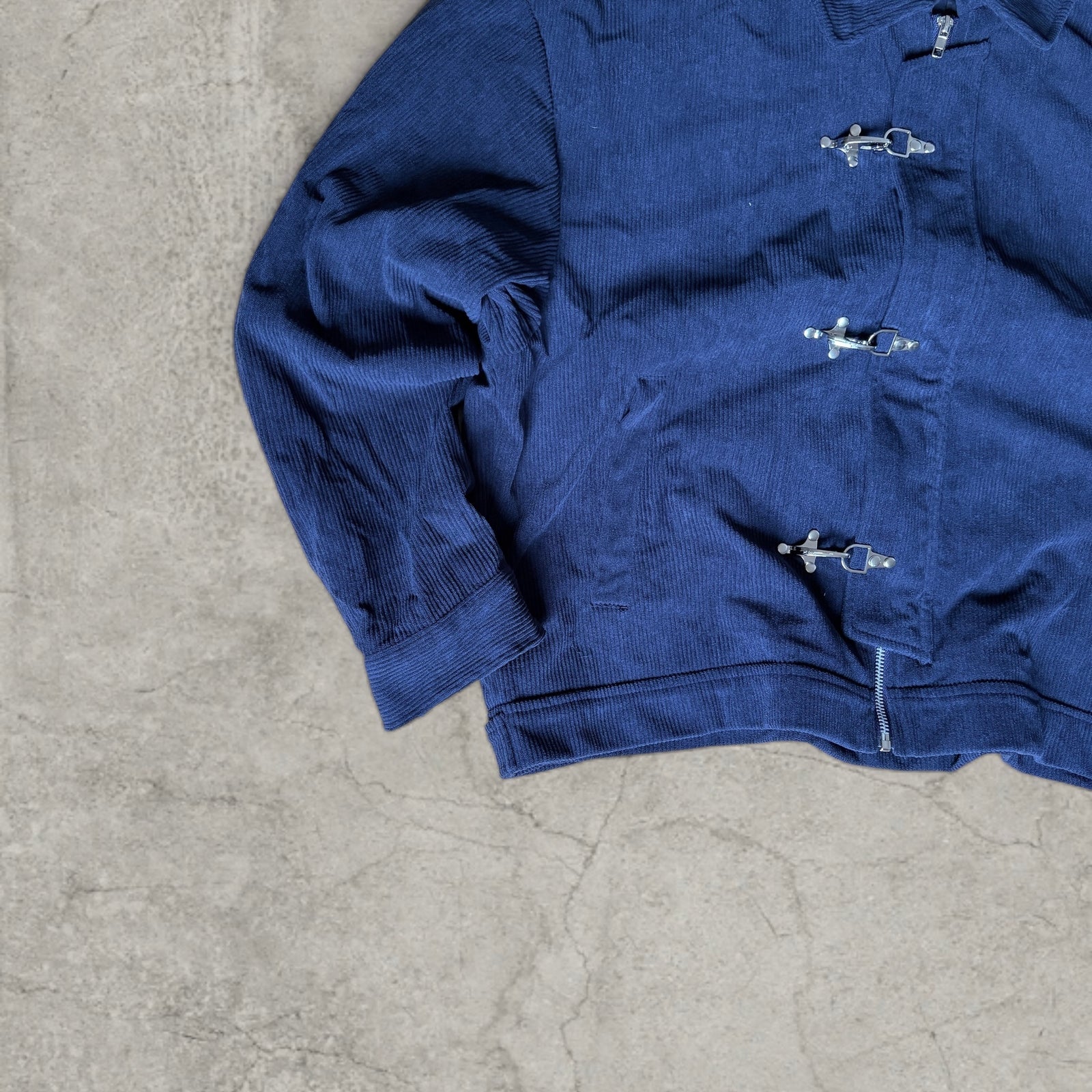 Collared bomber jacket with silver clasp fastenings in navy blue