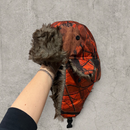 Russian ushanka hat in red/black camo tree print with grey faux fur.