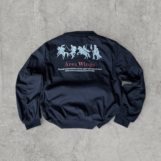 Black vintage style bomber jacket laid flat showing embroidered Ares Wings design on the back