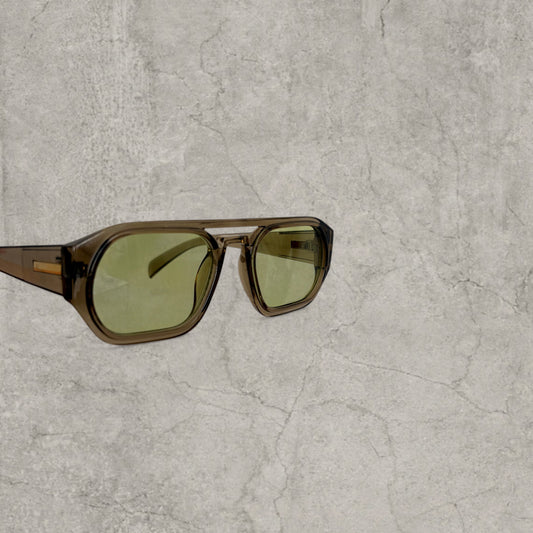 Close up view of aviator sunglasses with chunky khaki frame and green lenses against a textured grey background
