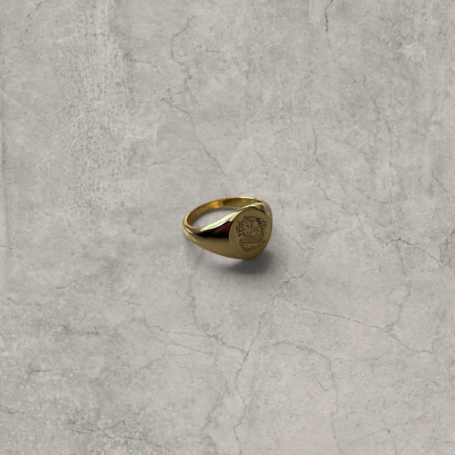 Cool vintage style gold colour stainless steel signet ring with engraved emblem.