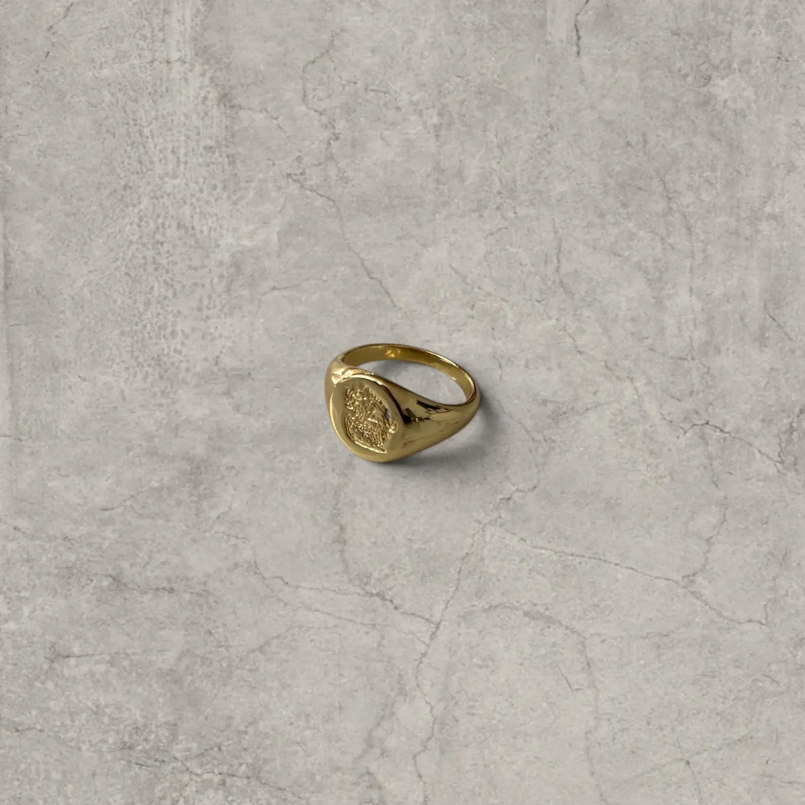Cool vintage style gold colour stainless steel signet ring with engraved emblem.