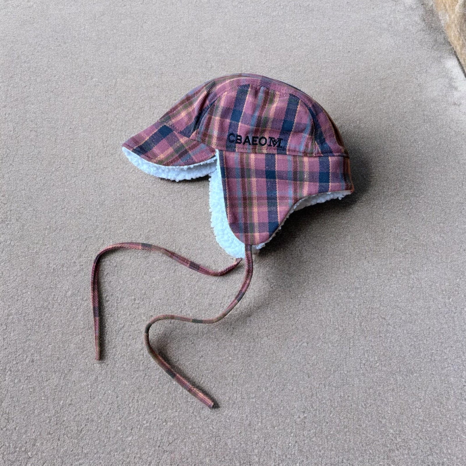 Trapper ear flap winter hat in checkered navy blue pink brown colour way. One size.