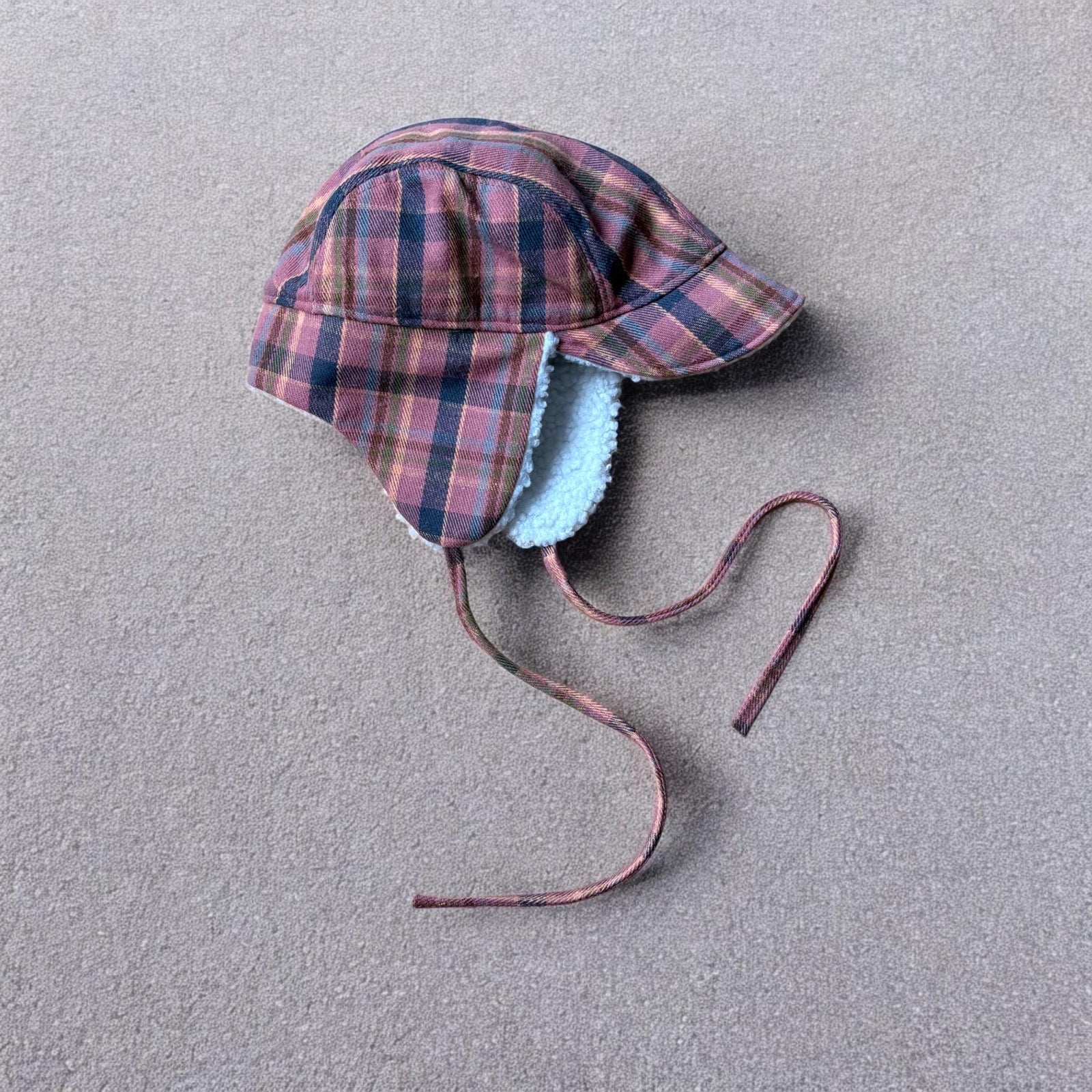 Trapper ear flap winter hat in checkered navy blue pink brown colour way. One size.