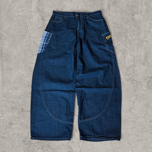 Wide leg skater jeans laid flat showing front view with navy blue fabric and blue plaid check pocket on left leg