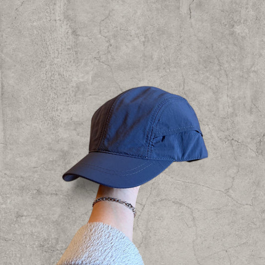 Navy Korean style hiking cap held in hand showing front and bill