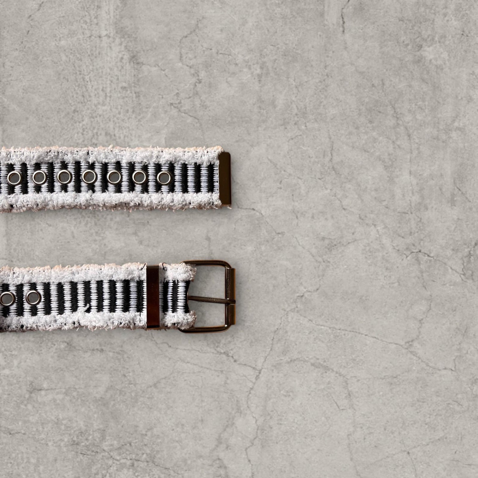 Cool distressed denim belt in black ad white with grey eyelet and silver metal buckle. Adjustable