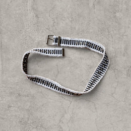 Cool distressed denim belt in black ad white with grey eyelet and silver metal buckle. Adjustable