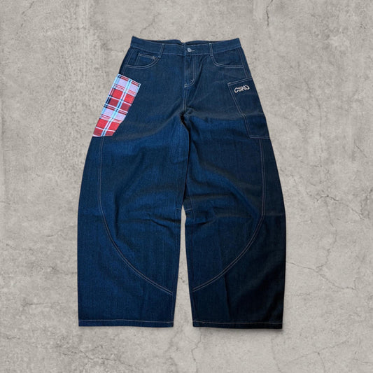 Front view of wide-leg navy blue denim jeans with red plaid patch pocket on left thigh and embroidery on right thigh pocket