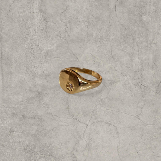Gold colour signet ring with smooth oval face and small diamante