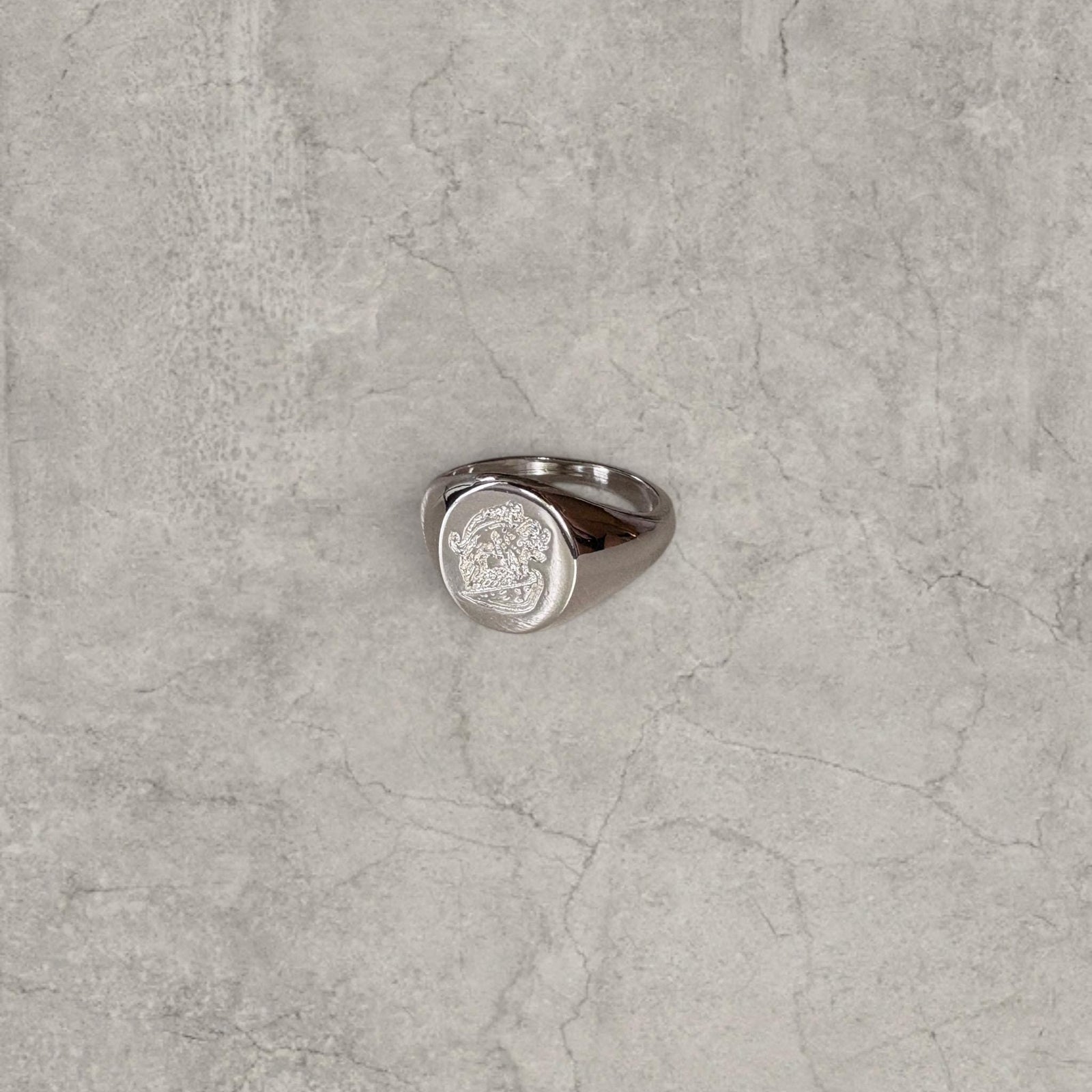 Cool vintage style silver colour stainless steel signet ring with engraved emblem.
