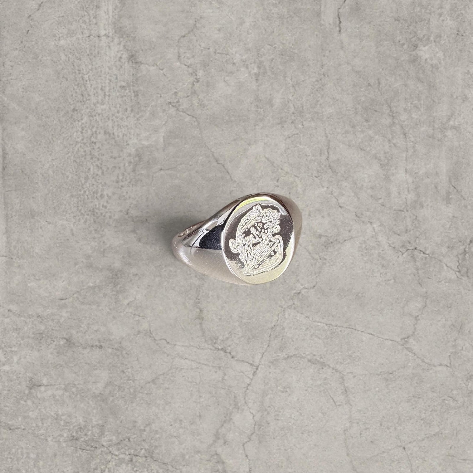 Cool vintage style silver colour stainless steel signet ring with engraved emblem.