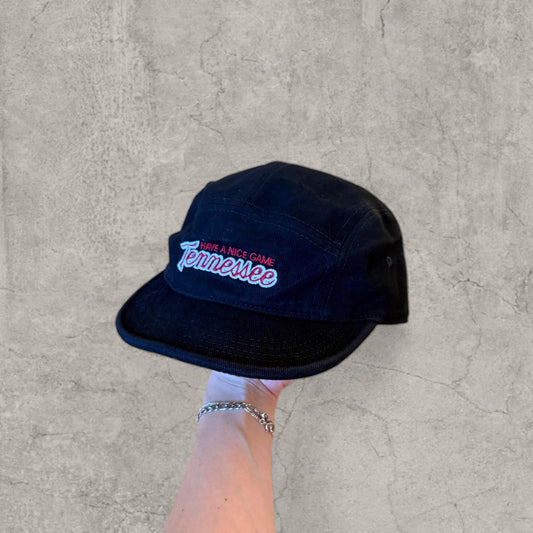 Black washed vintage baseball cap held in hand showing red and white Tennessee logo on front panel