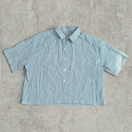 Green and white striped boxy short sleeve shirt with collar and button front laid flat