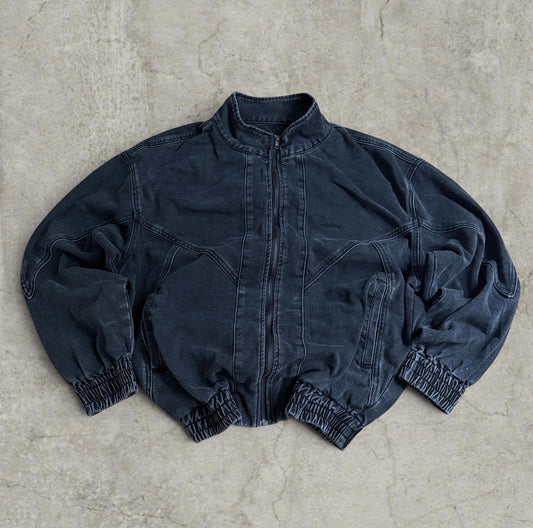 Black and grey denim bomber jacket laid flat showing front zip and collar