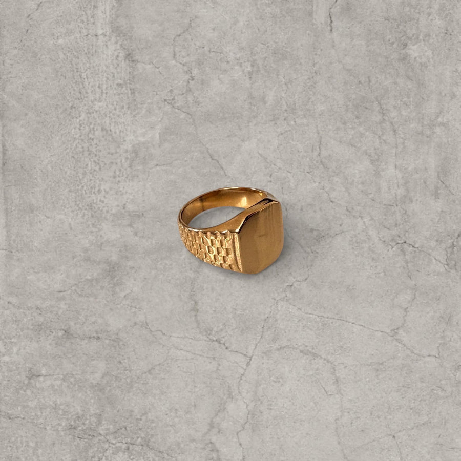 Gold colour stainless steel signet ring with square face and checkered detailing on band sides