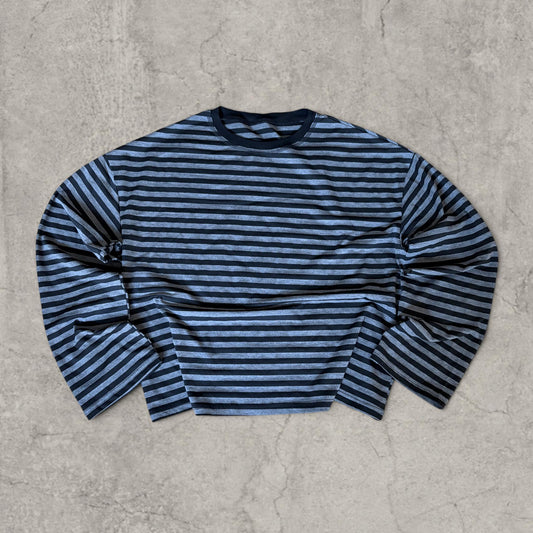 Relaxed fit long sleeve T-shirt top with black and grey stripes laid flat on grey surface showing front
